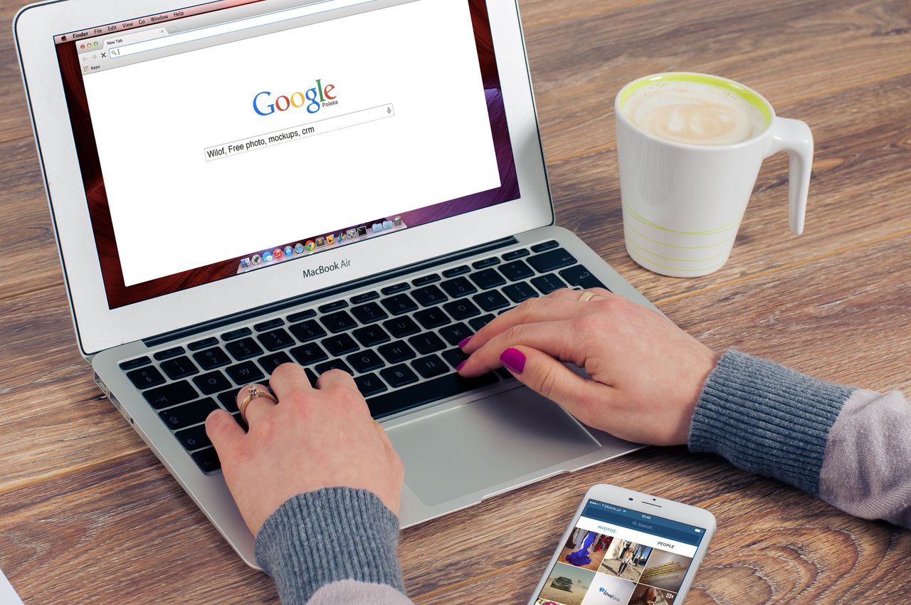 Mastering the First Impression: Your intriguing post title goes here Hands typing on MacBook Air with Google search open, coffee nearby.