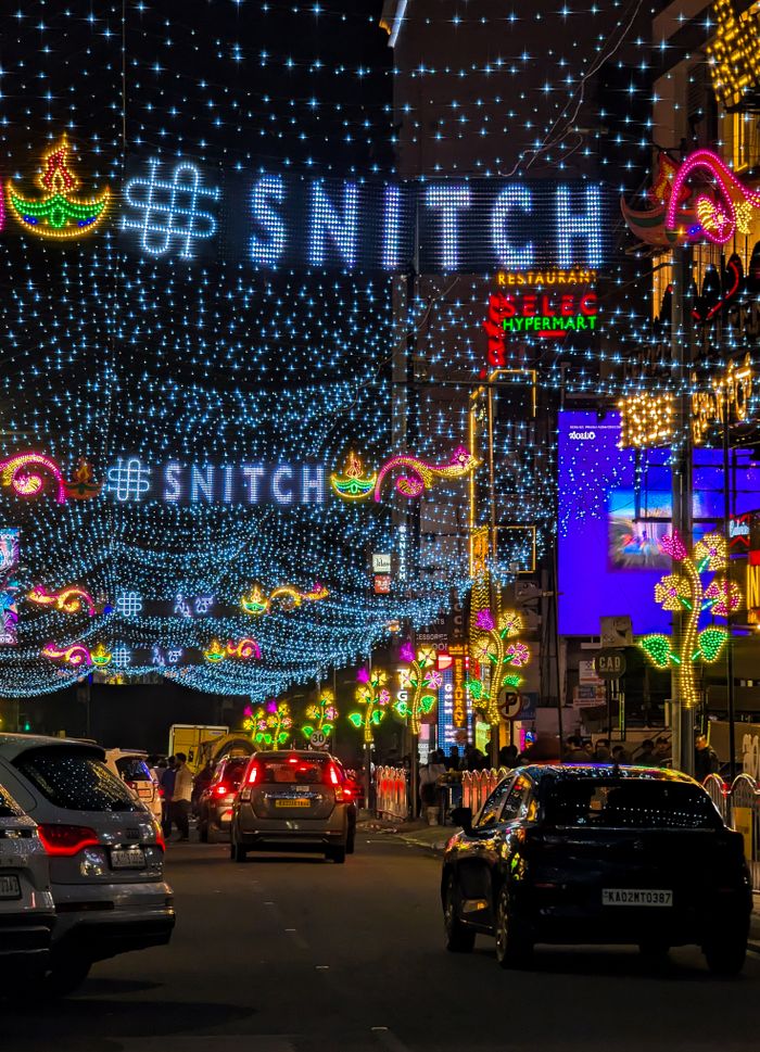 Crafting Captivating Headlines: Your awesome post title goes here Colorful street decorated with festive lights and cars driving at night.